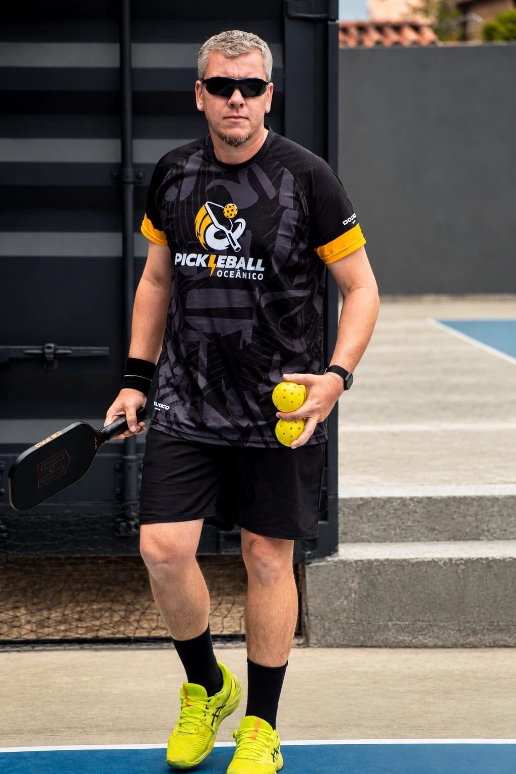 João Mattos, fundador da Pickleball Academy, na quadra com a raquete e as bolas