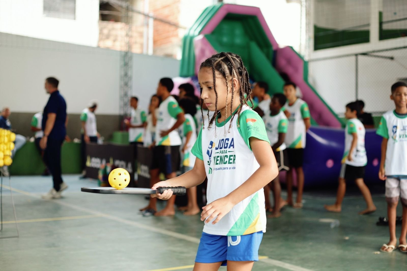Menina do projeto Joga para Vencer equilibrando a bola na raquete